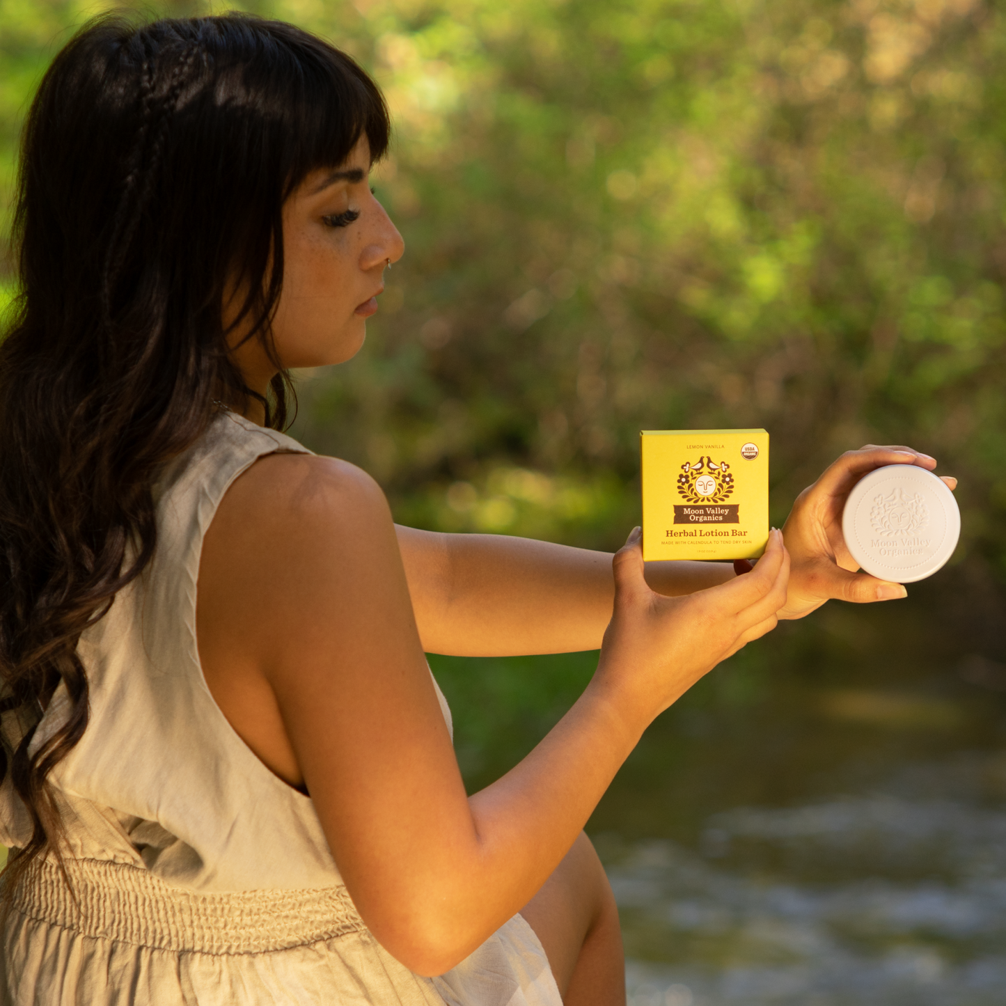 Moon Valley Organics Herbal Lotion Bar Hand Woman holds Lemon Vanilla box and tin