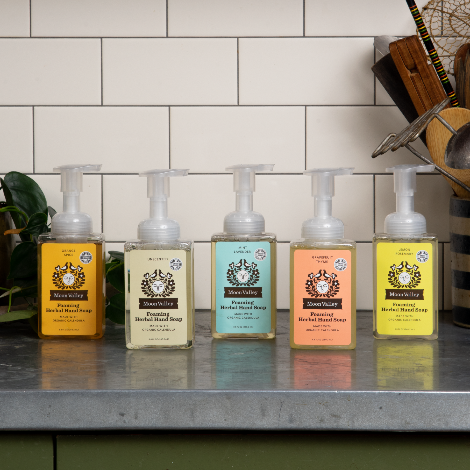 Moon Valley Organics Foaming Herbal Hand Soap Dispenser Bottles Assortment of all scents on a modern kitchen countertop